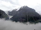 A rocky peak pokes out of the cloud