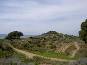 A big sand dune, and the sea in the background